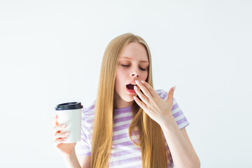 Young blondie woman with cup of coffee yawn, bored, tired, and exhausted. Girl wants to sleep