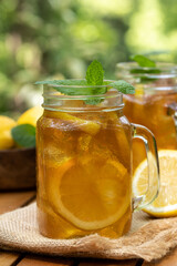 Ice tea in glass jars with lemon and mint
