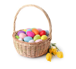 Wicker basket with beautifully painted Easter eggs and tulips isolated on white