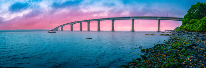 Dramatic beautiful stormy sunset panorama over Jamestown Verrazzano Bridge and Narragansett Bay in...