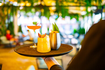 glasses alcohol cocktail set on a waiter tray in bar