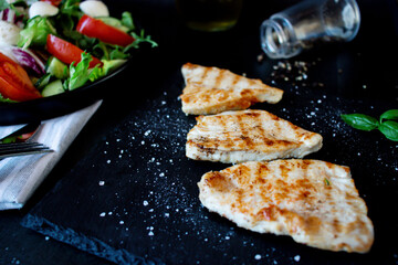 Salad with chicken fillet and lettuce. on a black background.