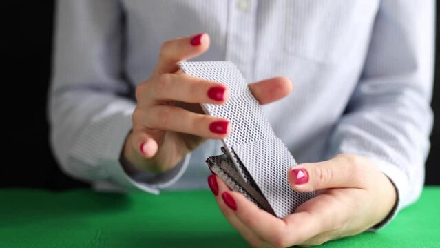 Woman mixing playing cards with hands in casino video. Gambling addiction concept