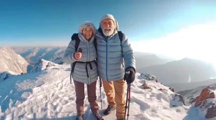 Foto auf Leinwand Happy smile elderly couple of hikers in the ascent to the summit take a selfie phone on the snow highlands landscape around © Salsabila Ariadina