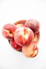 ripe peaches on a white background. top view. close up. fresh peaches in a bowl on a white background.