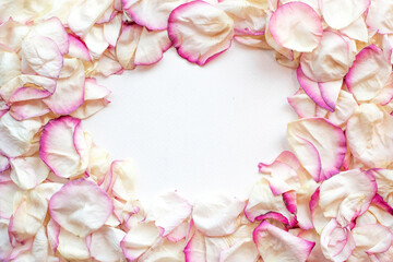 Obraz na płótnie Canvas Frame made of pink rose petals on white.