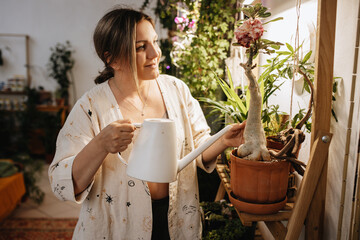 woman watering flowering adenium plant