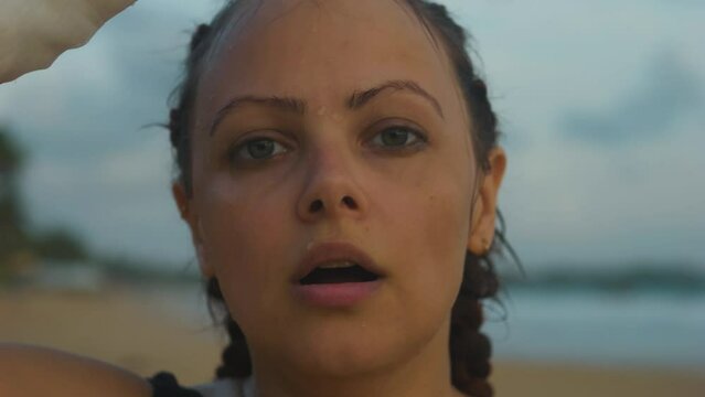 Female boxer MMA fighter splashing herself with water from bottle. Close up.