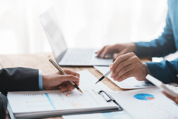 Successful Business Team Meeting Pointing at Graph for Strategic Planning and Growth. Teamwork Meeting with Graph Analysis and Collaboration. Corporate Collaboration and Analysis Concept.