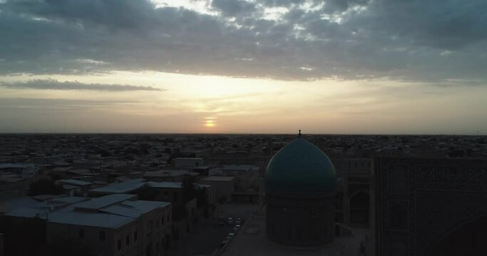The drone flies at dawn over the old Bukhara and the memorial famous Kalyan Poi Kalon complex and Poi Kalon Minaret, Poi Kalan or Po-i-Kalyan and Mir Arab Madrasah