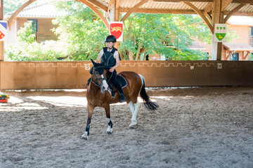 Beautiful young rider with green eyes during her riding lesson