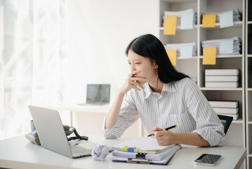 Woman who is tired and overthinking from working with tablet and laptop at modern office.