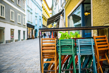 Fototapeta na wymiar Colorful empty chairs at a restaurant in Salzburg, concept of leisure, relaxation