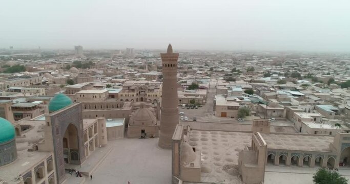 A drone flies around the famous memorial complex Kalyan Poi Kalon Complex and Poi Kalon Minaret, Poi Kalan or Po-i-Kalyan in Bukhara at dawn