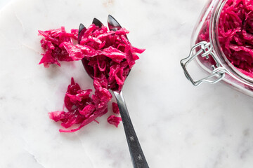 A serving fork filled with pickled beet and red cabbage sauerkraut.