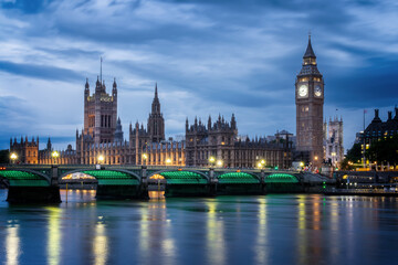 View of Westminster palace and bridge over river Thames with Big Ben illuminated at night in...