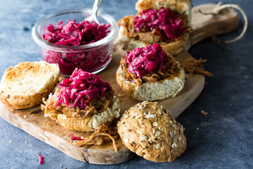 Pulled pork slider buns topped with pickled beet and red cabbage sauerkraut.