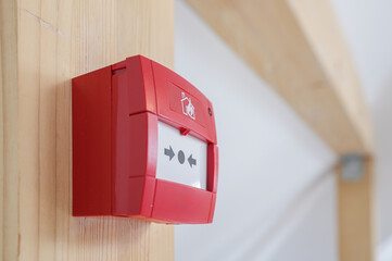 Emergency fire alarm button on a wooden pole inside the attic of a house. Emergency alert devices.