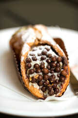 Classic Sicilian cannoli - crisp tubes of golden-brown fried dough filled with a creamy ricotta, candied fruit, and chocolate filling