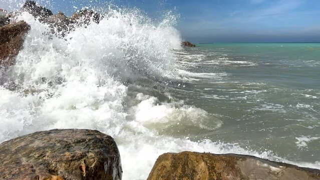 Untitled ProjectWaves splash on stones in sea. Breakwater with sea waves. Wave at stone pier. Wave in a storm breaks on stones at pier. Waves splash on stones at coast beach. Sea waves breaking on roc