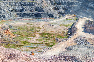 View of a Working Stone Quarry with Excavator and Mining Machine
