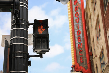 street light with traffic signals, displaying the colors red, green, and yellow. The walking sign...