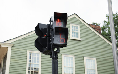 street light with traffic signals, displaying the colors red, green, and yellow. The walking sign indicates pedestrian safety and the flow of urban life