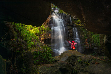 Young woman hiking on beautiful waterfall in Phu Wiang National Park, Tad Fah waterfall, Khon Kaen  province, ThaiLand.