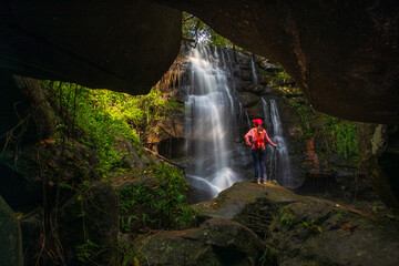 Young woman hiking on beautiful waterfall in Phu Wiang National Park, Tad Fah waterfall, Khon Kaen  province, ThaiLand.