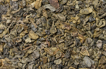 Fototapeta na wymiar Twisted dry green tea leaves, healthy drink, full frame