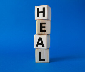 Heal symbol. Concept word Hate on wooden cubes. Beautiful blue background. Healthcare and Heal concept. Copy space.