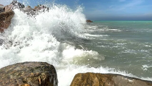 Untitled ProjectWaves splash on stones in sea. Breakwater with sea waves. Wave at stone pier. Wave in a storm breaks on stones at pier. Waves splash on stones at coast beach. Sea waves breaking on roc