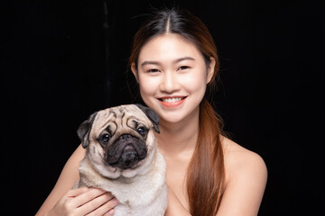 Asian woman hugging dog pud breed with love happiness emotional isolated on black background