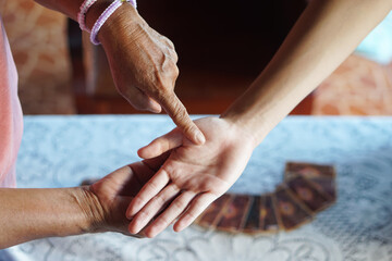 Fortune teller finger points on customer's  palm . Concept , palmistry, astrology. Foretelling,...
