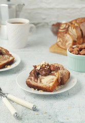 A piece of marble biscuit with chocolate cream and nuts	