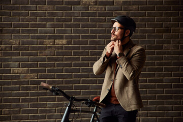 A businessman in a suit adjusts a helmet and prepares for a bicycle ride.