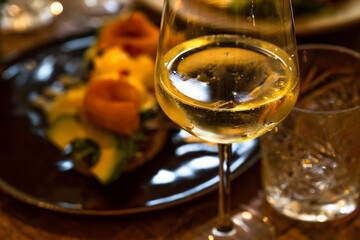 Glass of wine and plate with food on restaurant table. - 617799144