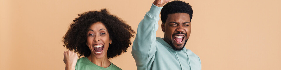 Black man and woman laughing and gesturing as winners