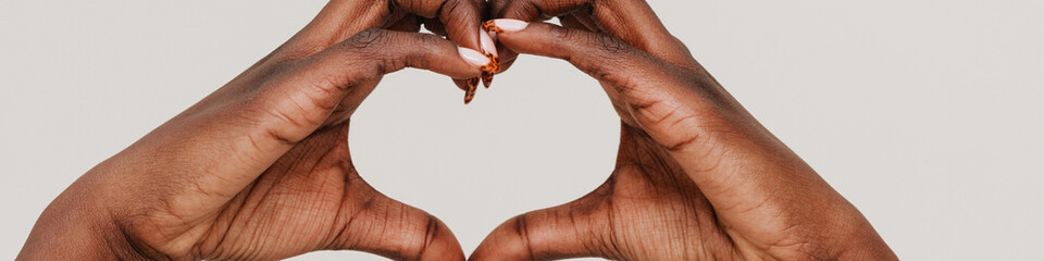 Female hands of african woman showing heart gesture with fingers