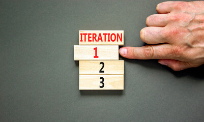 Time to iteration 1 symbol. Concept word Iteration 1 2 3 on wooden block. Businessman hand....