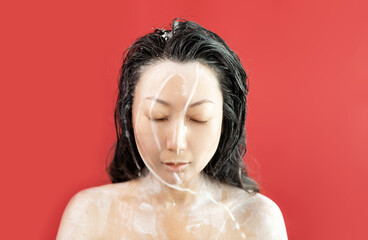 Asian woman washing her hair with pure coconut milk. Face of aesthetic model with splash, skin care...