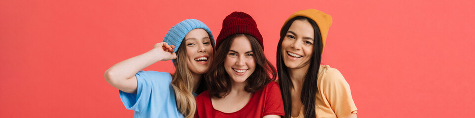Three young happy girls smiling and posing at camera