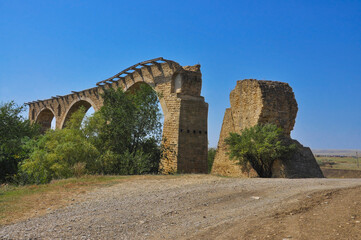 Stone old ruined railway bridge against the blue sky