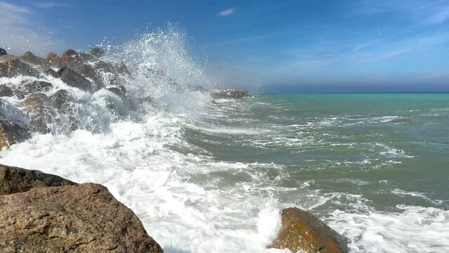 Untitled ProjectWaves splash on stones in sea. Breakwater with sea waves. Wave at stone pier. Wave in a storm breaks on stones at pier. Waves splash on stones at coast beach. Sea waves breaking on roc
