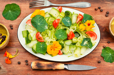 Fresh green salad with nasturtium leaves and flowers.