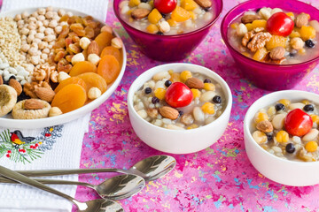 Uncooked Ashura ingredients plate designed on pink surface with Ashura Bowls
