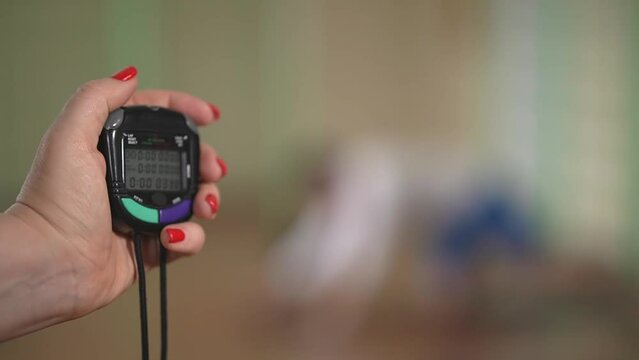 Hands hold a timer. a woman with a red manicure holds a stopwatch in her hand. close-up. High-quality video recording in FullHD format