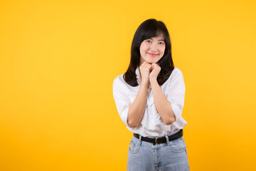 Young asian woman wearing white shirt and denim jean plants feeling happy smile expresses happiness feels joyful isolated on yellow background. Positive feeling gesture concept.