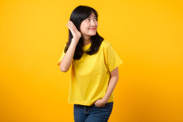Capture attention portrait of young Asian woman. Wearing a yellow t-shirt and denim jeans, leans in...