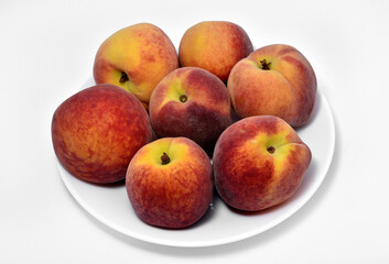 Juicy peaches on a white plate. Yellow-red large ripe peaches. Juicy fruits.